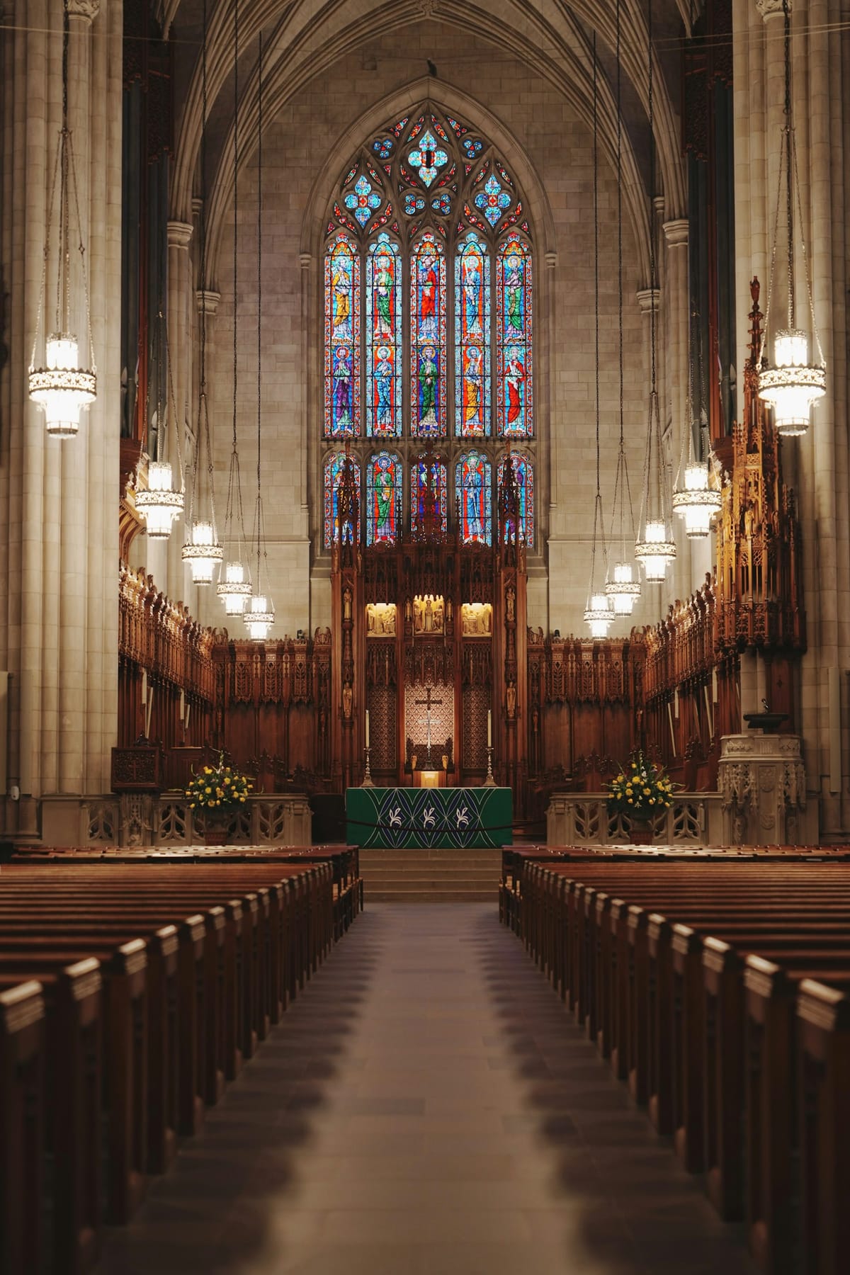 A large stone hall with rows of wooden pews
